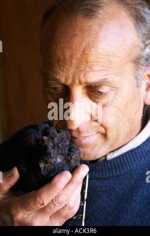 Hugues Martin, il proprietario dei tartufi azienda agricola un gigantesco fresco Perigord nero tartufo nella sua mano, del peso di circa 700 grammi Truffiere de la Bergerie (Truffière) tartufi farm Ste Foy de finchéil Dordogne Francia Foto Stock