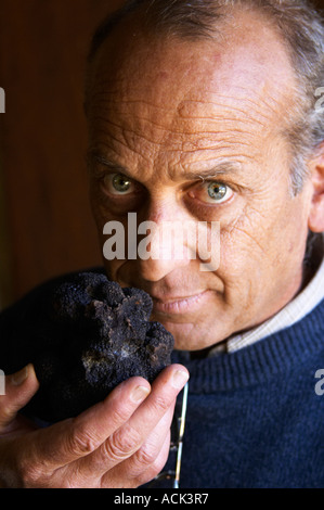 Hugues Martin, il proprietario dei tartufi azienda agricola un gigantesco fresco Perigord nero tartufo nella sua mano, del peso di circa 700 grammi Truffiere de la Bergerie (Truffière) tartufi farm Ste Foy de finchéil Dordogne Francia Foto Stock