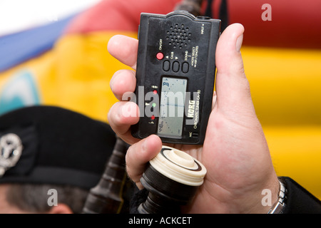 Uomo con Korg Accordatore cromatico Ca-30 ad assistere con la sintonizzazione della cornamusa scozzese, Scotland Regno Unito Foto Stock