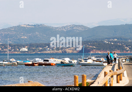 Vista da Sanary sul mare verso la terraferma montagne provenzale, barche ormeggiate a boe in acqua e di persone a piedi lungo l'acqua Le Brusc Six Fours Var Costa Azzurra Francia Foto Stock
