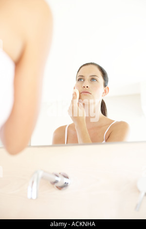 Una giovane donna l'applicazione di polvere sul suo viso Foto Stock