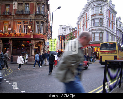Il centro di Londra Inghilterra Regno unito con i pedoni a camminare su una strada trafficata scena Foto Stock