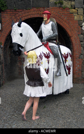 Un modello di un cavaliere a cavallo con il suo serf situato nel cortile del Castello di Carrickfergus Foto Stock