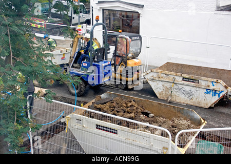 Gli uomini al lavoro su strada gli scavi in strada residenziale durante la Londra di fognatura e rete idrica rinnovi nel villaggio Brackenbury, London, England Regno Unito Foto Stock