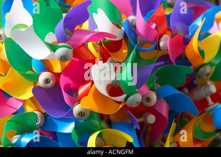 Collezione colorata di mulini a vento per bambini ammucchiati in vendita in un negozio di mare portstewart Foto Stock