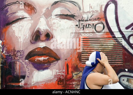 Portatori di flottazione di fronte un graffiti, la Settimana Santa, Siviglia, Spagna, 2006 Foto Stock