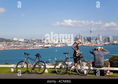 I ciclisti in appoggio sul Monte Victoria Devonport vista sobborgo di Auckland orientale dello skyline della città attraverso il porto Waitemata Foto Stock