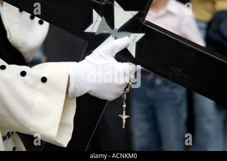 Penitente di fratellanza Montesion recanti una croce durante il Giovedì Santo processioni, Siviglia, Spagna, 2006 Foto Stock