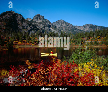 Uomo in canoa Pagaie sulla foto lago nel nord la Cascade Mountain Range di Washington Foto Stock