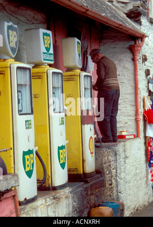 Un vecchio uomo tendendo le pompe di benzina Foto Stock