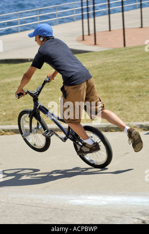 Ragazzo adolescente fare acrobazie sul suo bmx bike Foto Stock