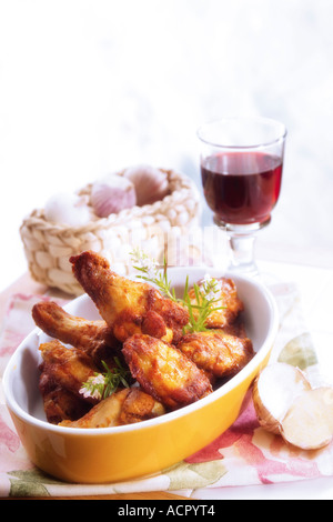 Cosce di pollo con un bicchiere di vino rosso Foto Stock