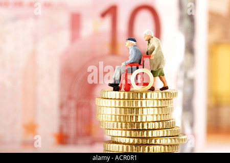 Figurine, cittadini anziani, sulla pila di monete Foto Stock
