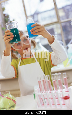 La ragazza (8-9) in laboratorio chimico di indossare gli occhiali protettivi Foto Stock