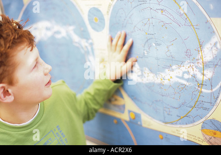 Ragazzo (10-11) guardando alla mappa del mondo, close-up Foto Stock