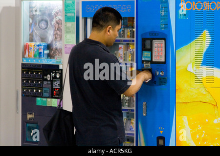 Uomo cinese di acquistare da uno Snack Distributore PVG Aeroporto Internazionale di Pudong Shanghai in Cina Foto Stock