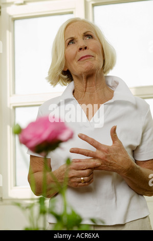 Senior woman standing, guardando in alto, ritratto Foto Stock