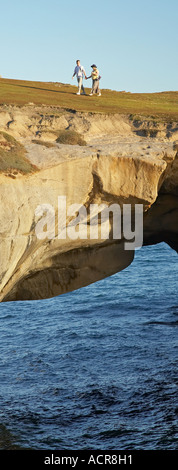 Giovane su Arco Naturale Spiaggia Tunnel Dunedin Isola del Sud della Nuova Zelanda Foto Stock