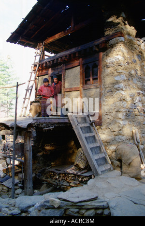 Padre e figlio di stand nella porta della loro casa a paro Bhutan Foto Stock