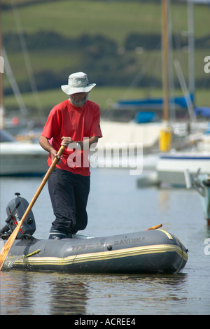 Sailor prendendo il suo gommone al suo yacht in Roseland Cornwall Inghilterra Foto Stock
