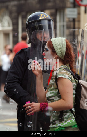 Gli stati dei ribelli clandestino ribelle Esercito Clown bolle nella parte anteriore di un poliziotto antisommossa Foto Stock