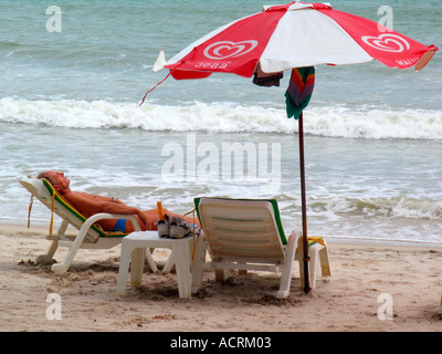 L uomo si rilassa sulle sdraio Patong Beach dopo lo tsunami isola di Phuket Thailandia Foto Stock