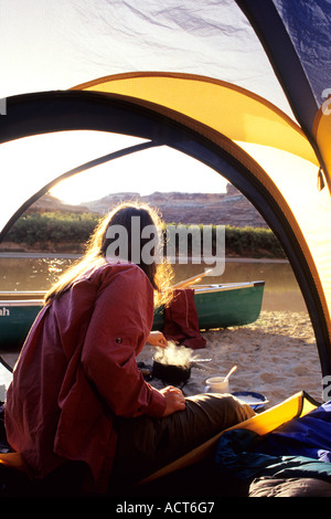 Donna cooking per colazione in canoa camp, Green River, Utah, il Parco Nazionale di Canyonlands Foto Stock