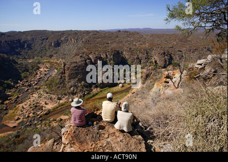 Tre turisti seduto su una roccia che si affaccia Lanner Gorge e il fiume Luvuvhu Parco Nazionale Kruger Sud Africa Foto Stock