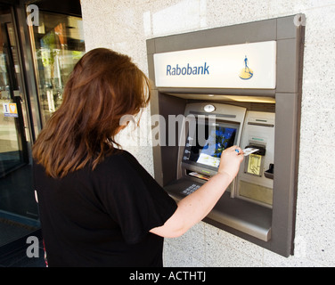 Donna che utilizza un Rabobank bancomat nei Paesi Bassi Foto Stock