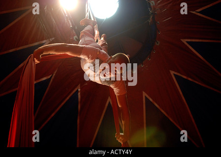 Circus acrobat performer tangled in drappi rossi Foto Stock