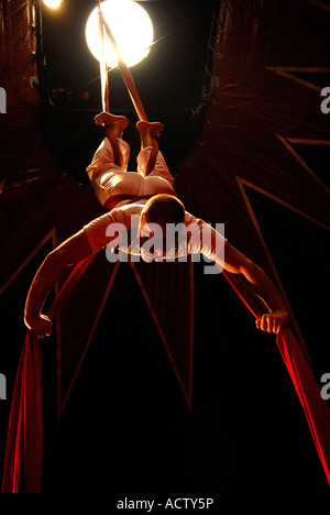 Circus acrobat performer tangled in drappi rossi Foto Stock