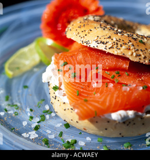 Fresche seminate Bagel riempito con salmone affumicato e crema di formaggio pasto servito su una piastra con n. di persone Foto Stock