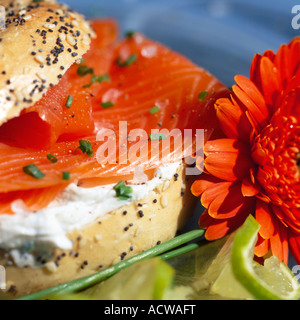 Fresche seminate Bagel riempito con salmone affumicato e crema di formaggio pasto servito su una piastra con n. di persone Foto Stock