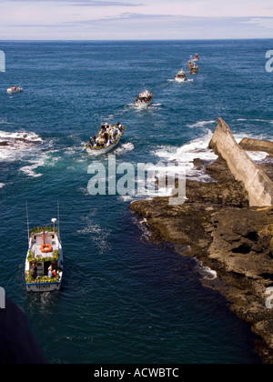 Le barche che partecipano nella flotta di fiori passano attraverso il canale stretto a Depoe Bay in Oregon Foto Stock
