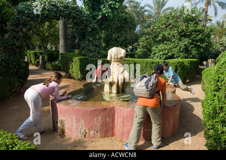 Bambini che giocano con una fontana di acqua nei giardini dell'Alcazar di Cordoba, Andalusia Spagna meridionale Foto Stock