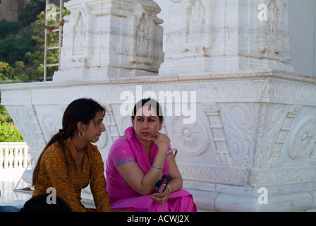 Due ragazze seduto sul pavimento e parlare con ciascun altro Foto Stock