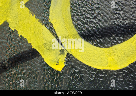 Immagine grafica di giallo e nero testo graffiti astratti e vicino sul vetro di ghiaia Foto Stock
