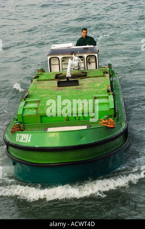 Solo uso editoriale nessun modello di rilascio di colore immagine verticale di un verde immondizia barca pilotato da un cestino italiano uomo a Venezia Italia Foto Stock