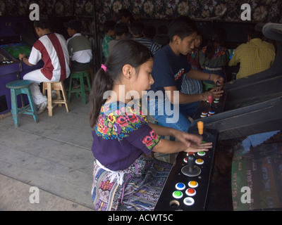 Indigenously vestito kids play video giochi rendendo un contrasto di international vs local Foto Stock