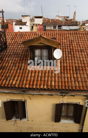 Guardando sopra i tetti di Venezia Italia con terra cotta le assicelle e piatti sattelite antenne e torre campanile Foto Stock