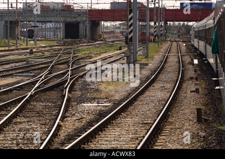 Colore immagine orizzontale di treni sui binari del treno in corrispondenza di una stazione di commutazione con un ponte che porta il trattore di autocarri in Italia Foto Stock