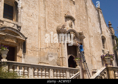 Lavoratore su una scala stringing le luci sulla parte anteriore della chiesa di San Giuseppe su aprile 9 Plaza a Taormina Italia sulla Sicilia Foto Stock