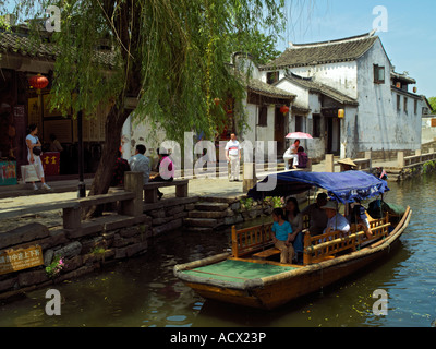 Una barca turistica su un canale nella città di Zhouzhuang Foto Stock