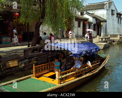 Una barca turistica su un canale nella città di Zhouzhuang Foto Stock