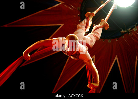 Circus acrobat performer tangled in drappi rossi Foto Stock