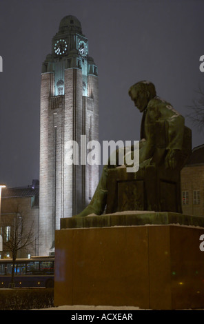 Statua di scrittore finlandese Aleksis Kivi e la torre dell orologio della principale stazione ferroviaria a Rautatientori, Helsinki, Finlandia, UE. Foto Stock