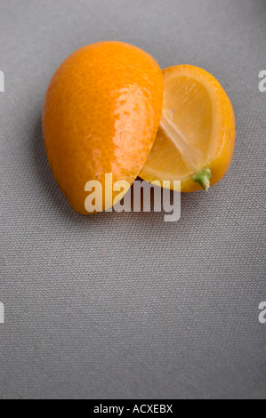 Fette di Kumquat - Citrus Fortunella su un tessuto grigio sfondo Foto Stock