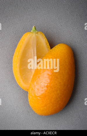 Fette di Kumquat - Citrus Fortunella su un tessuto grigio sfondo Foto Stock