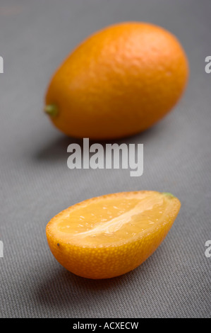 Fette di Kumquat - Citrus Fortunella su un tessuto grigio sfondo Foto Stock