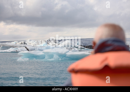 Un turista guardando Iceberg di Jokulsarlon laguna glaciale nel Skaftafell National Park, Islanda Foto Stock